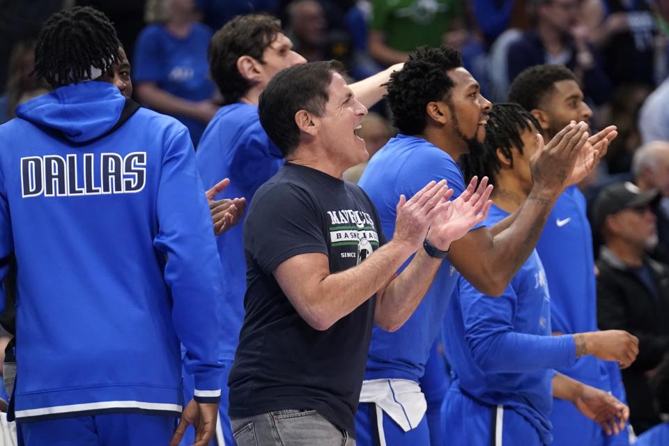 Dallas Mavericks team owner Mark Cuban, center, and players on the bench cheer on their team's play against the Utah Jazz in the first half of Game 2 of an NBA basketball first-round playoff series, Monday, April 18, 2022, in Dallas. (AP Photo/Tony Gutierrez)