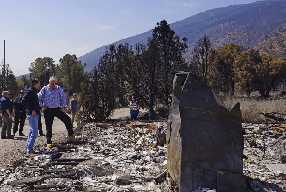 California Gov. Gavin Newsom, left, and Nevada Gov. Steve Sisolak talk as they tour destroyed home by wildfires near where the Tamarack Fire ignited earlier in July in Gardnerville, Nev., Wednesday, July 28, 2021. Nevada Gov. Steve Sisolak and California Gov. Gavin Newsom stood on ashen ground as they surveyed burned homes and a mountain range of pine trees charred by the Tamarack Fire south of Gardnerville, Nevada, near Topaz Lake. The governors, both Democrats, called on the federal government to provide more firefighting resources and stressed that climate change could make wildfires even more intense and destructive in the future. (AP Photo/Sam Metz)