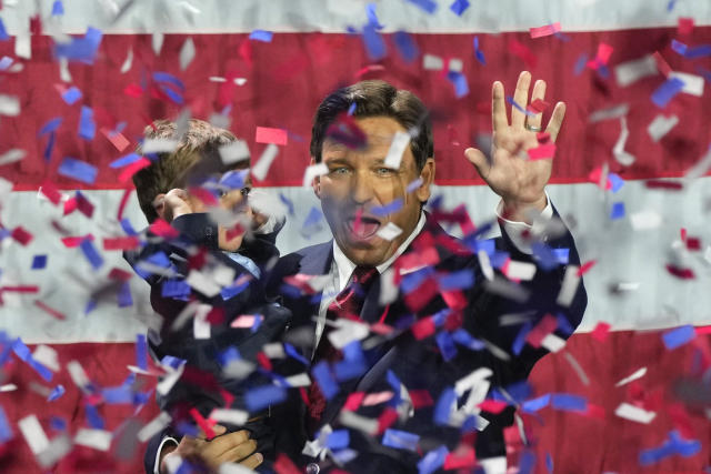 Florida Gov. Ron DeSantis holds his son as confetti rains down around them.