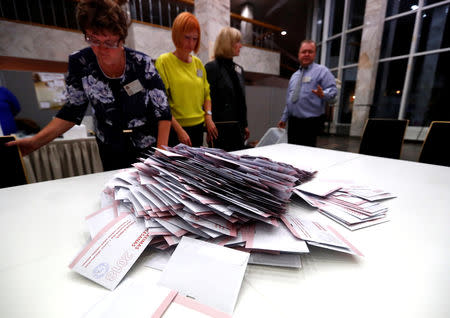 Election officials open ballot box during a general election in Riga, Latvia October 6, 2018. REUTERS/Ints Kalnins