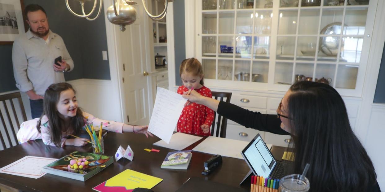 <span class="caption">Schooling at home is hard for all parents, including teleworkers.</span> <span class="attribution"><a class="link " href="https://www.gettyimages.com/detail/news-photo/sarah-yunits-checks-her-daugher-adas-homework-while-cora-news-photo/1207811290" rel="nofollow noopener" target="_blank" data-ylk="slk:Matthew J. Lee/The Boston Globe via Getty Images;elm:context_link;itc:0;sec:content-canvas">Matthew J. Lee/The Boston Globe via Getty Images</a></span>