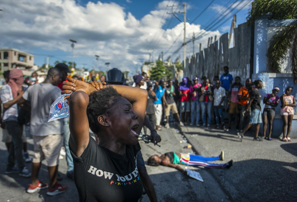 FILE - A woman cries near the body of another woman fatally shot by the police during a protest demanding the resignation of Prime Minister Ariel Henry in the Delmas area of Port-au-Prince, Haiti, Monday, Oct. 10, 2022. (AP Photo/Odelyn Joseph, File)