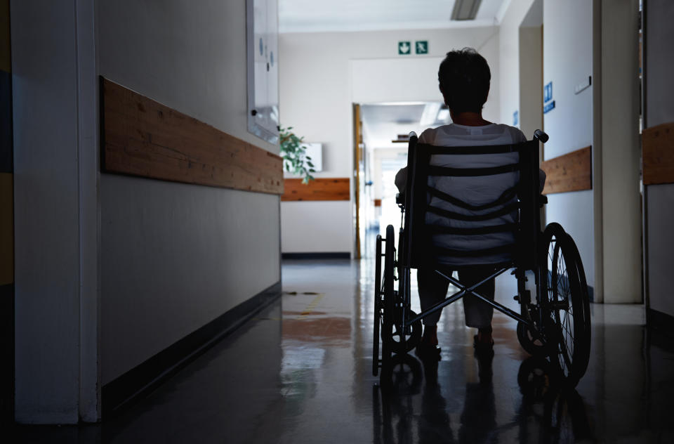 Person in a wheelchair facing a corridor, possibly contemplating work challenges or accessibility issues