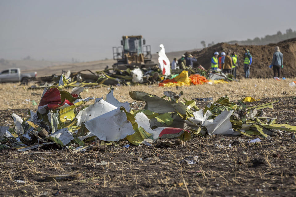 Rescue workers at Bishoftu, or Debre Zeit, outside Addis Ababa, Ethiopia, Monday, March 11, 2019, where Ethiopia Airlines Flight 302 crashed Sunday. Investigators are trying to determine the cause of a deadly crash Sunday involving a new aircraft model touted for its environmentally friendly engine that is used by many airlines worldwide. (AP Photo/Mulugeta Ayene)