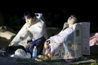 Evacuees use newspapers to warm themselves at Prefectural University of Kumamoto after an earthquake in Kumamoto, southern Japan, in this photo taken by Kyodo April 16, 2016. REUTERS/Kyodo