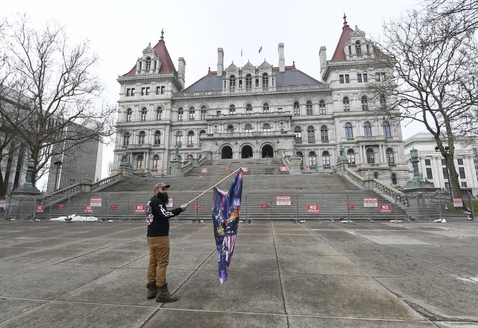 Trump supporter Mark Leggiero, of Florida, N.Y., holds a banner outside the New York state Capitol objecting to the inauguration of President Joe Biden on Wednesday. (Photo: AP Photo/Hans Pennink)