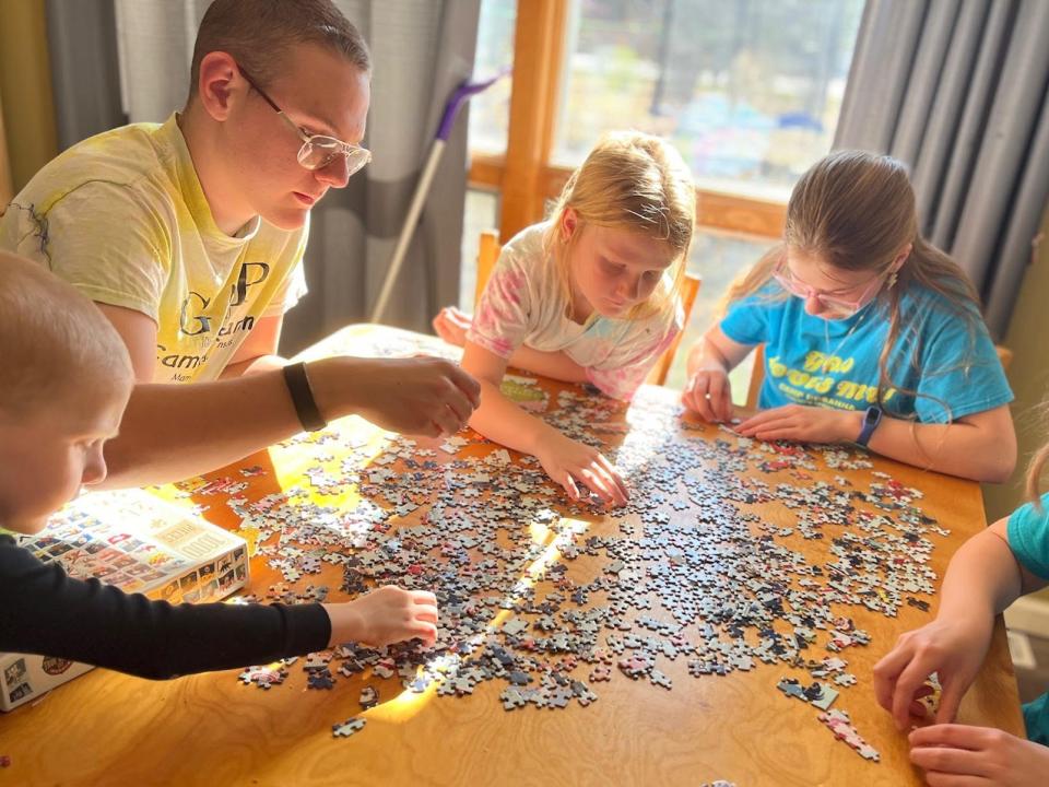 lisa's kids working on a puzzle on a big wooden table