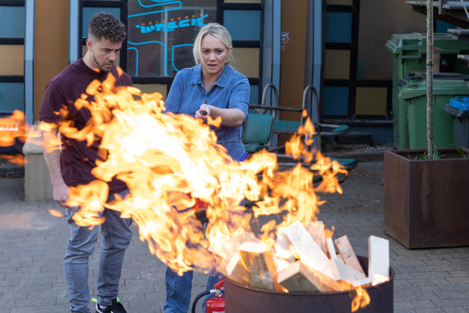 Leela Lomax and Joel Dexter struggling to put out a fire.