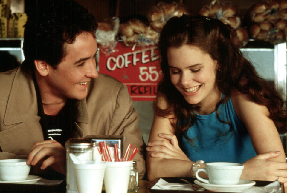 John Cusack and Ione Skye laughing at a diner