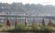 Buddhist monks walk along a stream in Seoul, South Korea, Tuesday, Oct. 27, 2020. About 100 monks and followers marched the 500 kilometer (310 mile) pilgrimage to pray for the country to overcome the coronavirus. (AP Photo/Lee Jin-man)