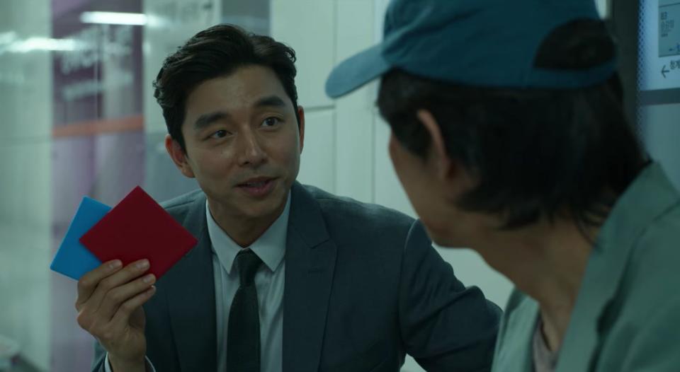 The businessman with ddakji trying to get Gi-hun to join "Squid Game"