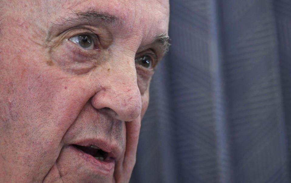 Pope Francis greets the journalists onboard the papal plane on the occasion of his five-day pastoral visit to Cyprus and Greece, Monday, Dec. 6, 2021. Francis' five-day trip to Cyprus and Greece has been dominated by the migrant issue and Francis' call for European countries to stop building walls, stoking fears and shutting out "those in greater need who knock at our door." (Alessandro Di Meo/Pool photo via AP)