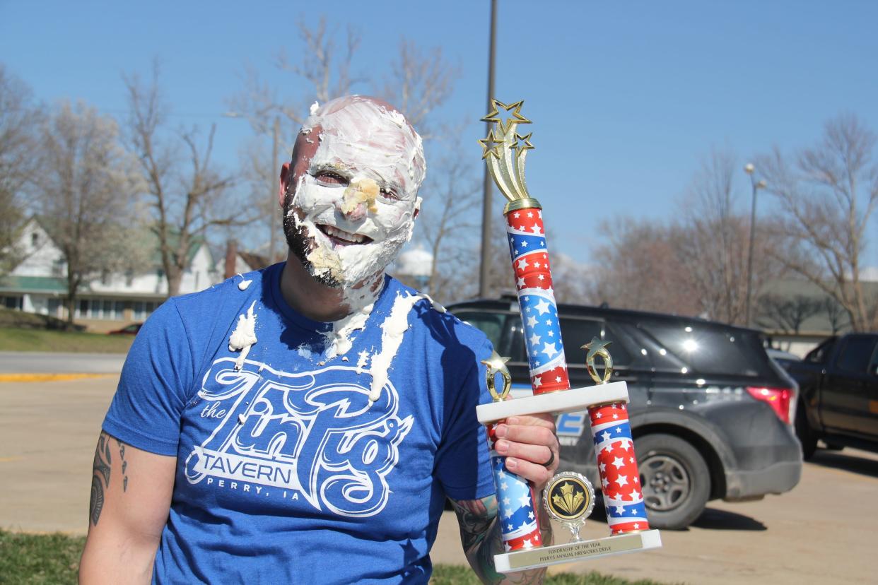 Alex Lott, with the Perry Police Department, poses for a photo with the Big Boom Bracket Battle Trophy during the grand finale on Monday, April 8, 2024.