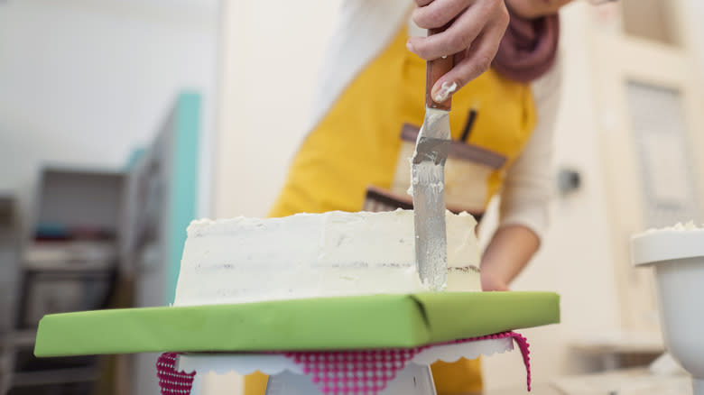 Person frosting the cake