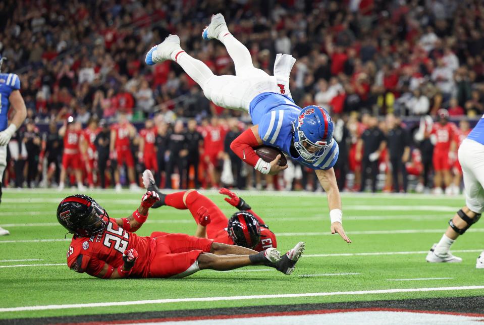 Mississippi quarterback Jaxson Dart (2) leaps and scores a touchdown as Texas Tech  defensive back Dadrion Taylor-Demerson (25) defends during the fourth quarter of the Texas Bowl at NRG Stadium.