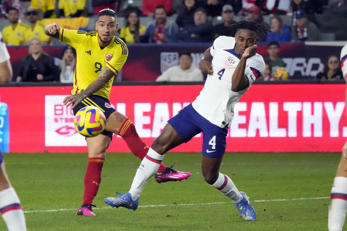 Colombia&#39;s Cristian Arango, left, takes a shot on goal next to United States&#39; DeJuan Jones during the first half of an international friendly soccer match Saturday, Jan. 28, 2023, in Carson, Calif. (AP Photo/Marcio Jose Sanchez)