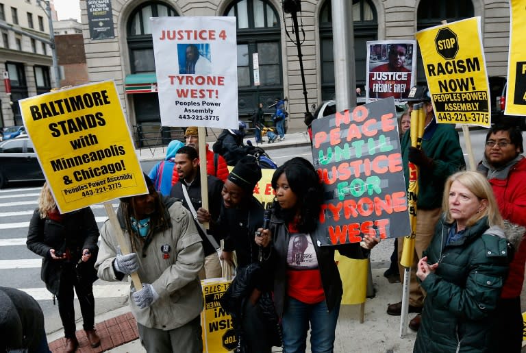 Protestors hold up signs in front of the courthouse where jury selection began in the trial of William Porter, one of six Baltimore city police officers charged in connection to the death of Freddie Gray on November 30, 2015 in Baltimore, Maryland