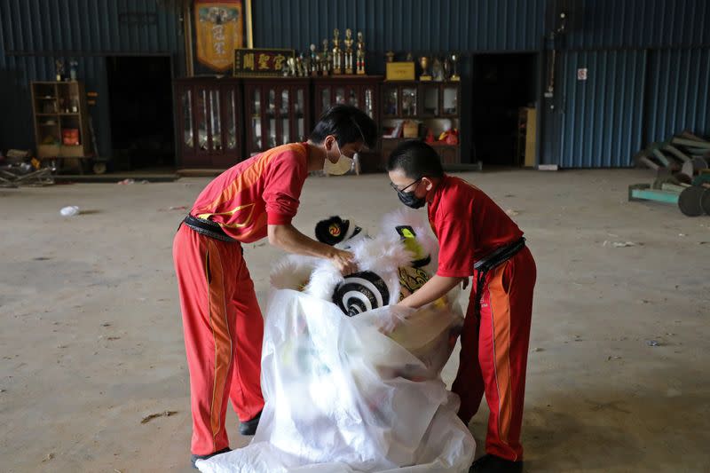 Members of Kun Seng Keng Lion and Dragon Dance Association, tidy up a traditional Chinese lion dance mask at a training centre, in Muar