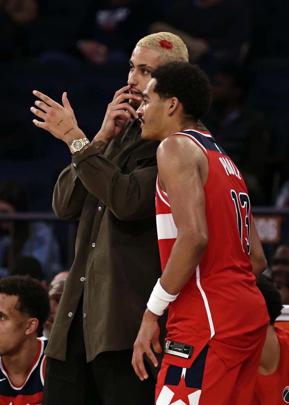 Washington Wizards guard Jordan Poole (13) talks with Kyle Kuzma, left, during the second half of a preseason NBA basketball game against the New York Knicks on Wednesday, Oct. 18, 2023, in New York. (AP Photo/Adam Hunger)