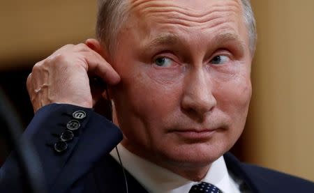 FILE PHOTO: Russian President Vladimir Putin listens as U.S. President Donald Trump speaks during their news conference in Helsinki, Finland July 16, 2018. REUTERS/Kevin Lamarque/File Photo