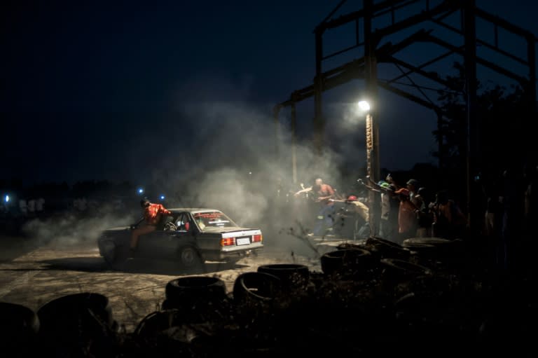 Spectators cheer on spinners performing stunts late into the night at the Midway spinning event in Soweto, on September 26, 2015