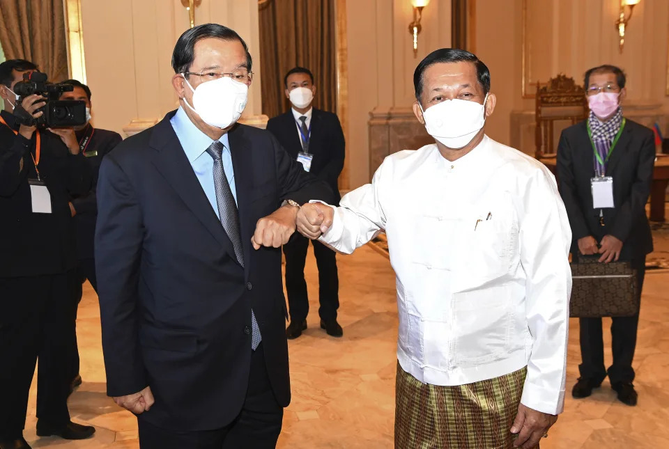 In this photo provided by An Khoun Sam Aun/National Television of Cambodia, Cambodian Prime Minister Hun Sen, left, greets with Myanmar State Administration Council Chairman, Senior General Min Aung Hlaing, right, during a meeting in Naypyitaw, Myanmar, Friday Jan. 7, 2022. Cambodian Prime Minister Hun Sen's visit to Myanmar seeking to revive peace efforts after last year's military takeover has provoked an angry backlash among critics, who say he is legitimizing the army's seizure of power. (An Khoun SamAun/National Television of Cambodia via AP)