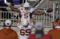 Texas running back Bijan Robinson (5) celebrates a touchdown with teammate Jake Majors (65) during the second half of an NCAA college football game against Kansas State in Manhattan, Kan., Saturday, Dec. 5, 2020. (AP Photo/Orlin Wagner)