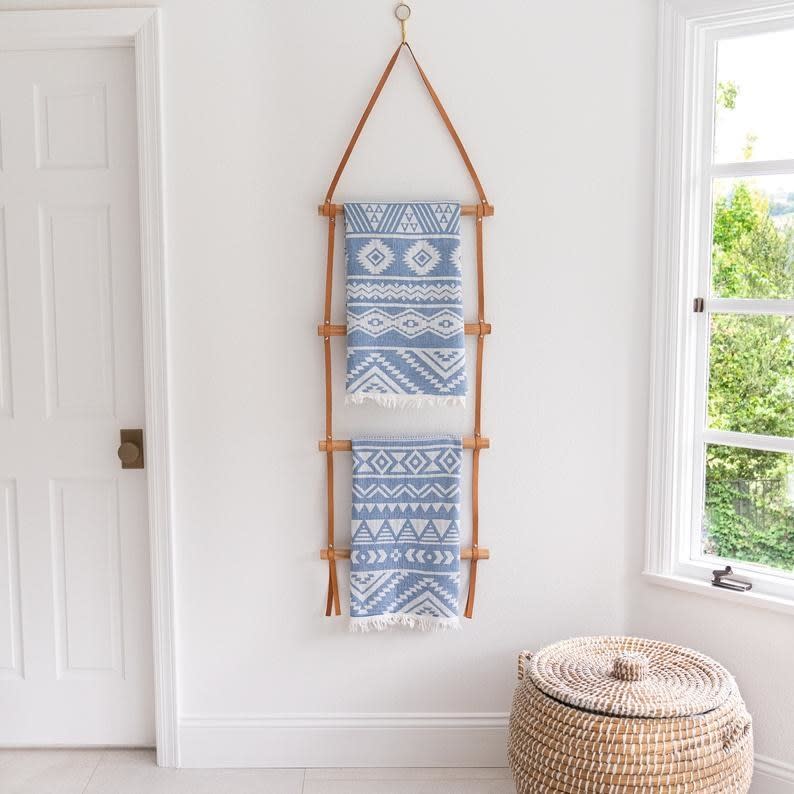 leather and wooden latter hung on wall in bathroom