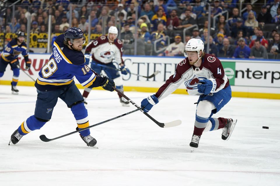 St. Louis Blues' Robert Thomas (18) shoots past Colorado Avalanche's Bowen Byram (4) during the second period in Game 3 of an NHL hockey Stanley Cup second-round playoff series Saturday, May 21, 2022, in St. Louis. (AP Photo/Jeff Roberson)