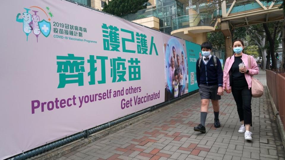 路人走過銅鑼灣香港中央圖書館社區疫苗接種中心外的大型宣傳橫幅（中新社圖片5/3/2021）
