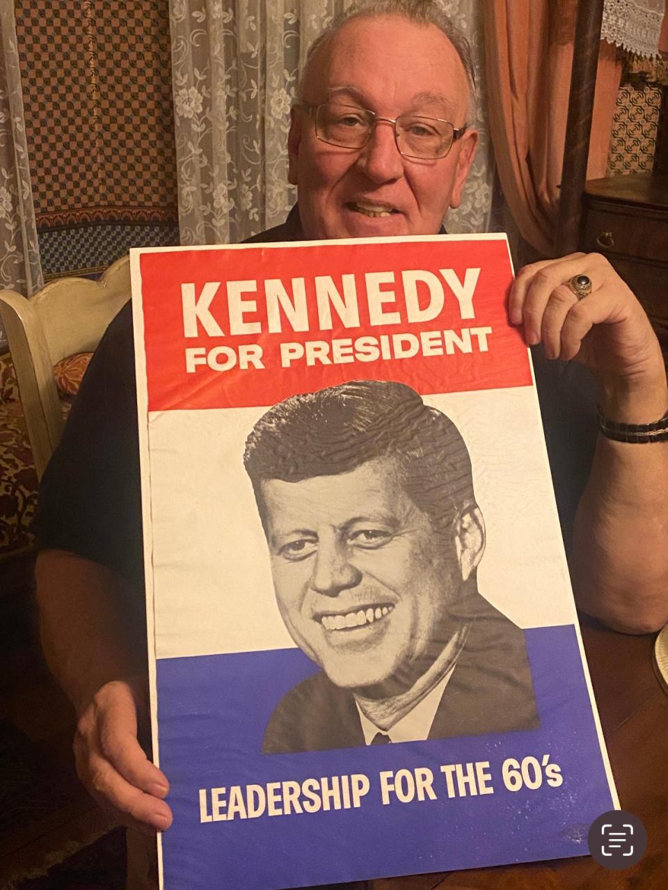 Listening to a speech in Canton by Democratic presidential candidate Sen. John F. Kennedy gave Randy Feemster a lifelong interest in collecting artifacts related to Kennedy. He holds a poster from the 1960 presidential campaign.