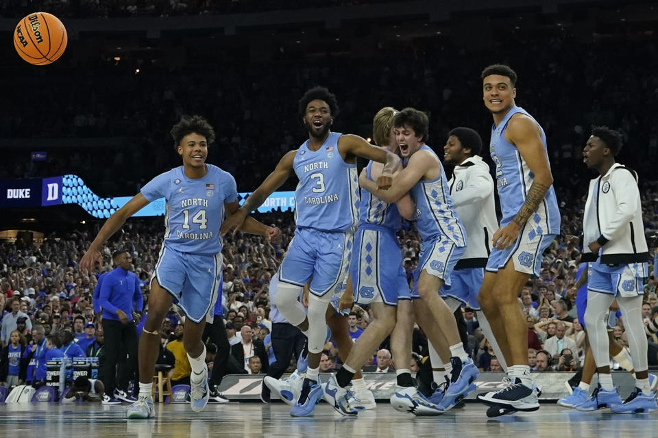 FILE - North Carolina players celebrate their victory against Duke after a college basketball game in the semifinal round of the Men's Final Four NCAA tournament, Saturday, April 2, 2022, in New Orleans. North Carolina won 81-77. With four starters back from the team that blew a 15-point halftime lead to Kansas at the Superdome in New Orleans, the Tar Heels were the runaway pick as the preseason No. 1 in the AP Top 25 on Monday, Oct. 17, 2022. (AP Photo/David J. Phillip, File)