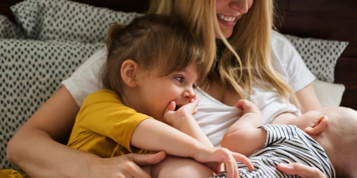 mom nursing a baby holding a toddler- breaking bigger