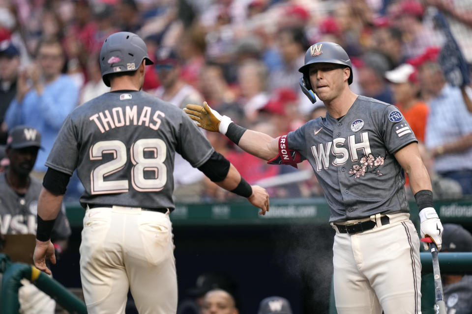 Washington Nationals' Corey Dickerson, right, greets teammate Lane Thomas after Thomas scored a run on Jeimer Candelario's double in the first inning of a baseball game against the Philadelphia Phillies, Friday, June 2, 2023, in Washington. (AP Photo/Patrick Semansky)