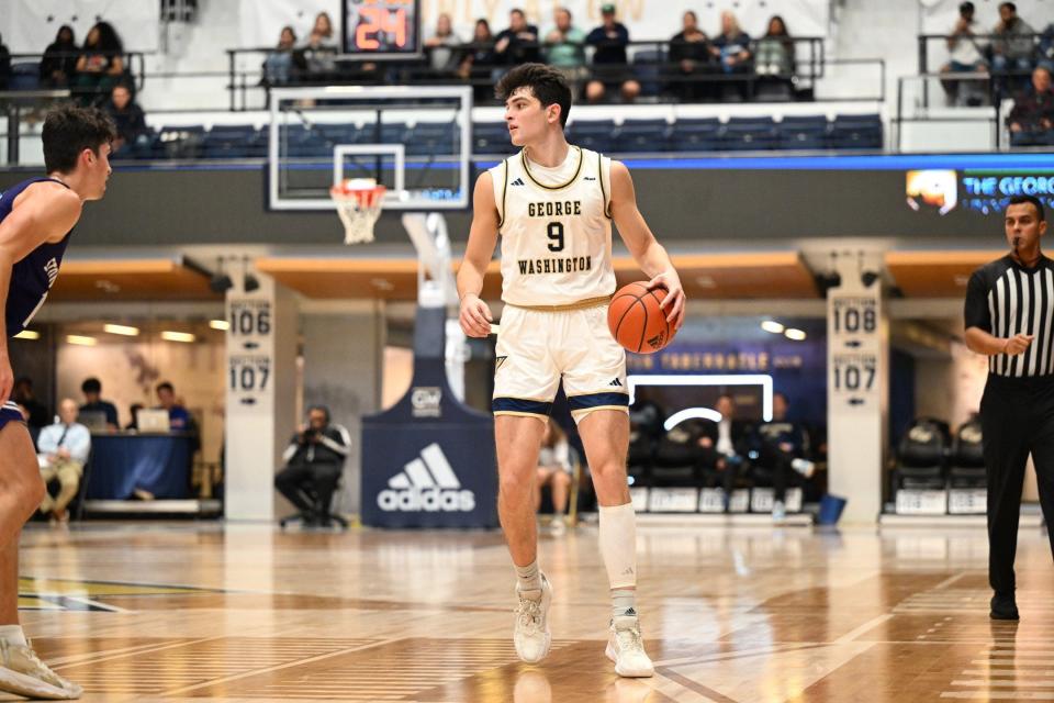 Garrett Johnson dribbles during George Washington's season opener against Stonehill.