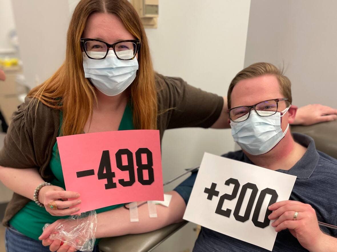 Glenn and Liz Cook pose for a photo as he makes his 200th donation. He aims to donate 498 units of blood in thanks for the 498 units of plasma his wife required in 2005. (Submitted by Liz Cook - image credit)