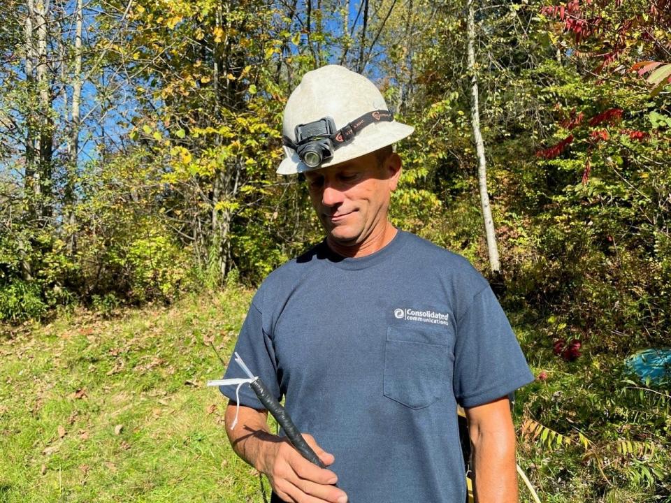 Mark Johnston, a lineman for Consolidated Cable, holds a fiber optic cable on Oct. 4, 2023, on Goose Pond Road in Fairfax, where he was helping to install the cable to bring high-speed internet to homes and businesses in the area.