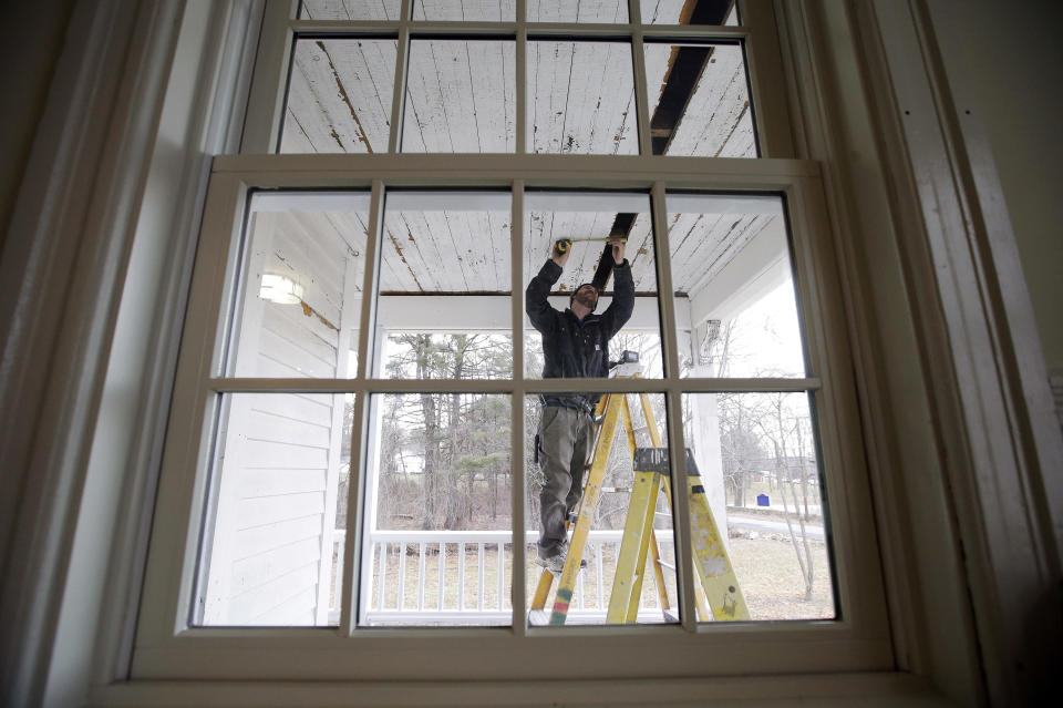 In this Thursday, Dec. 13, 2018 photo, carpenter Jeremy Parker works on a porch at the conclusion of a restoration of the home where Sarah Clayes lived, in Framingham, Mass., after leaving Salem, Mass., following the 1692 witch trials. Clayes was jailed during the witch trials but was freed in 1693 when the hysteria died down. (AP Photo/Steven Senne)