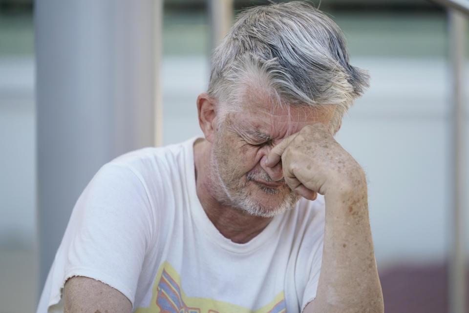 Jerry Frajman sits in front of the Cedar Rapids Public Library after charging his cell phone, Friday, Aug. 14, 2020, in Cedar Rapids, Iowa. The storm that struck Monday morning left more than 181,000 Iowans without power as of Friday morning. (AP Photo/Charlie Neibergall)