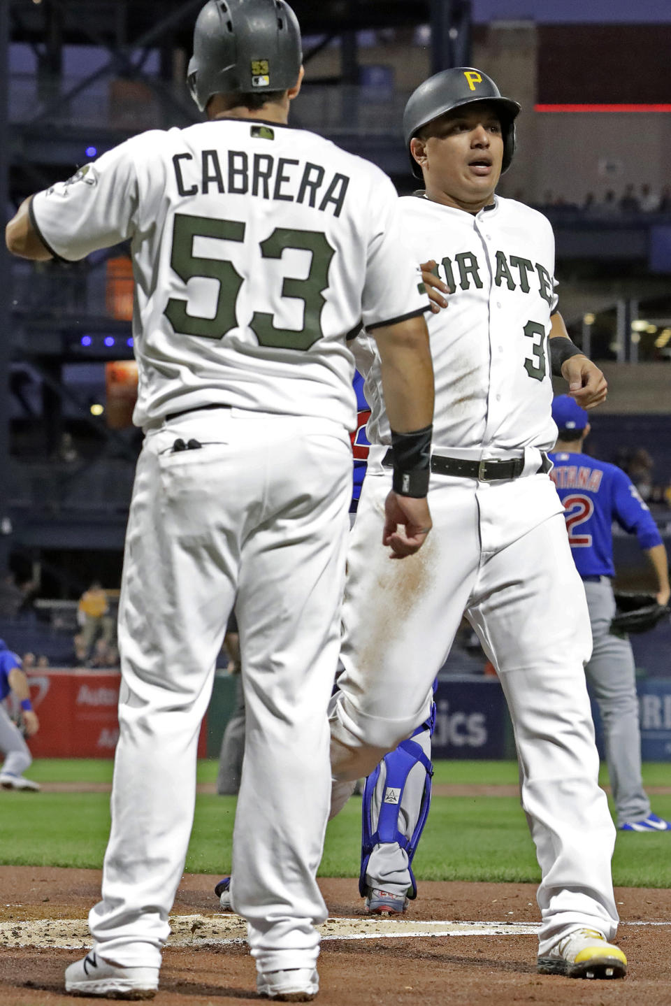 Pittsburgh Pirates' Jose Osuna, right, is greeted by Melky Cabrera (53) after they both scored on a triple by Pablo Reyes off Chicago Cubs starting pitcher Jose Quintana during the first inning of a baseball game in Pittsburgh, Thursday, Sept. 26, 2019. (AP Photo/Gene J. Puskar)
