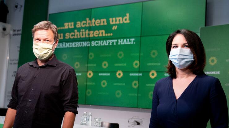 Annalena Baerbock und Robert Habeck kommen mit Mund-Nasenschutz zur Vorstellung des ersten Entwurfs zum neuen Grundsatzprogramm. Foto: dpa