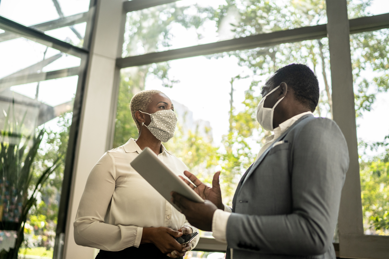 senior business conversation wearing masks