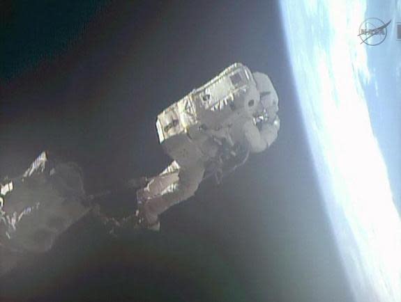 European Space Agency astronaut Luca Parmitano is moved via the International Space Station's robotic arm to a different part on the outside of the orbiting laboratory. Image released July 9, 2013.