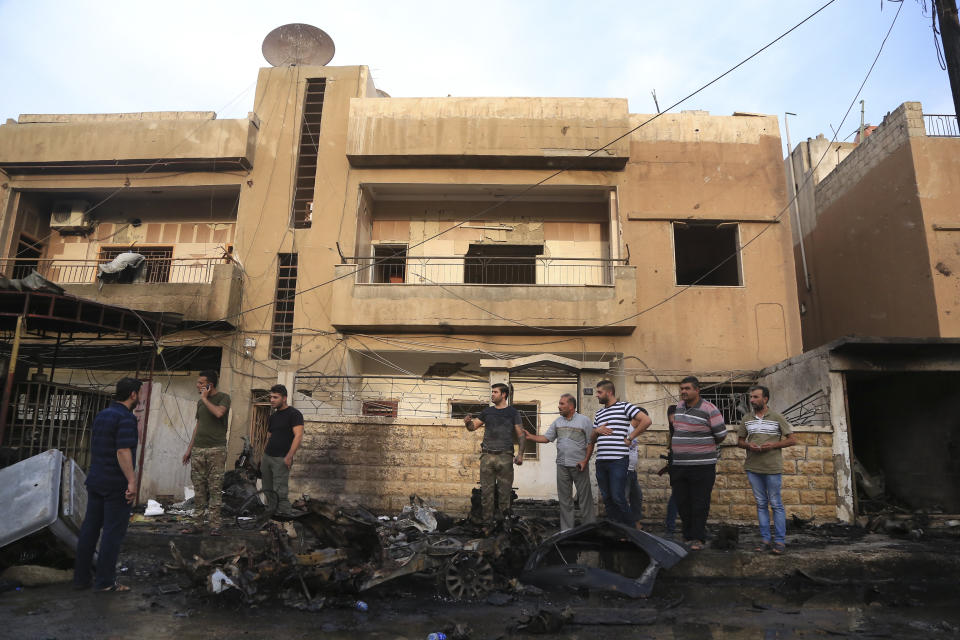 People gather after a car bomb exploded in the town of Qamishli, Syria, Friday, Oct. 11, 2019. Turkish forces faced intense resistance by U.S.-allied Syrian Kurdish fighters on the third day of Ankara's offensive, as casualties mounted, international criticism of the campaign intensified and an estimated 100,000 people fled the violence. (AP Photo/Baderkhan Ahmad)