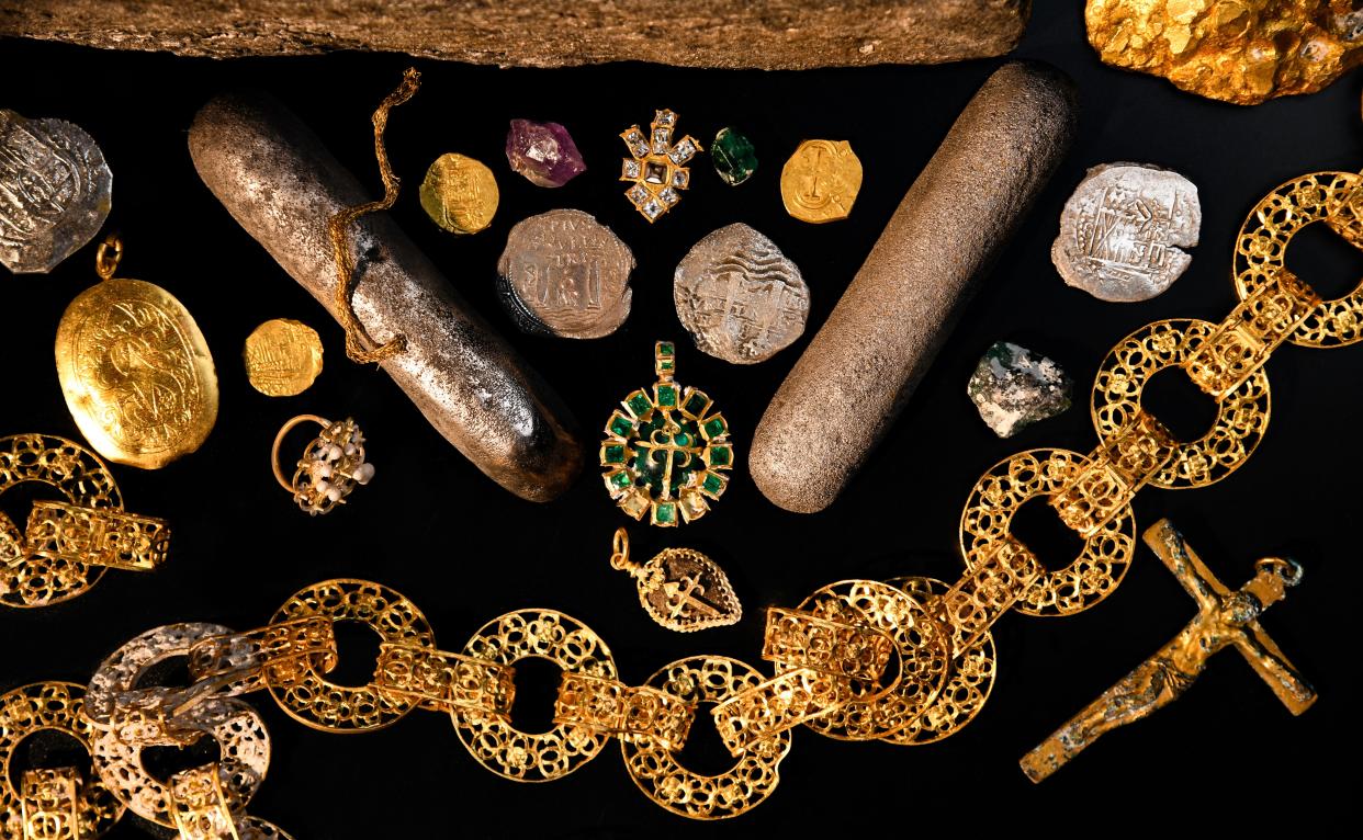 Gold jewelry and gems on black surface