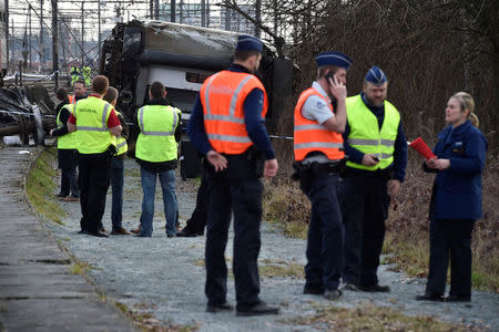 Rescuers and police officers stand next to the wreckage of a passenger train after it derailed in Kessel-Lo near Leuven, Belgium February 18, 2017. REUTERS/Eric Vidal