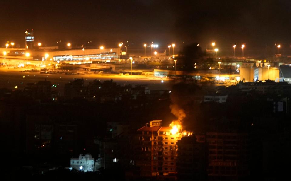 Flames and smoke rise from a building that was hit by an Israeli airstrike in Dahiyeh, as Rafik Hariri International airport is seen in the background