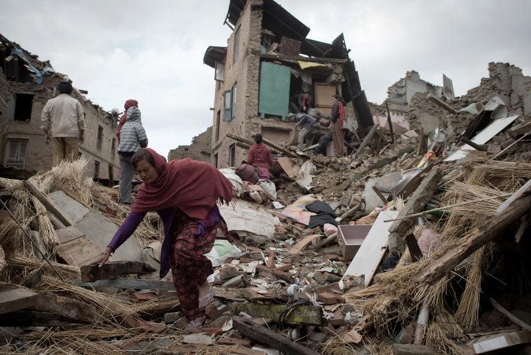 Nepalese residents look for their belongings among the rubbles of their destroyed homes in Sankhu on the outskirts of Kathmandu, on April 29, 2015