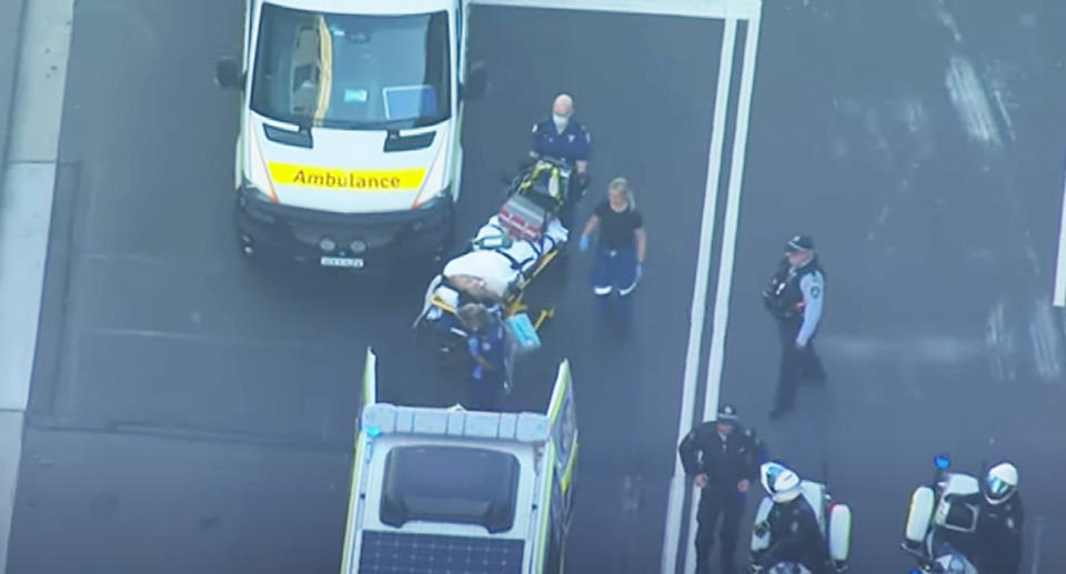 A patient is taken to an ambulance outside the Westfield shopping centre. Source: ABC