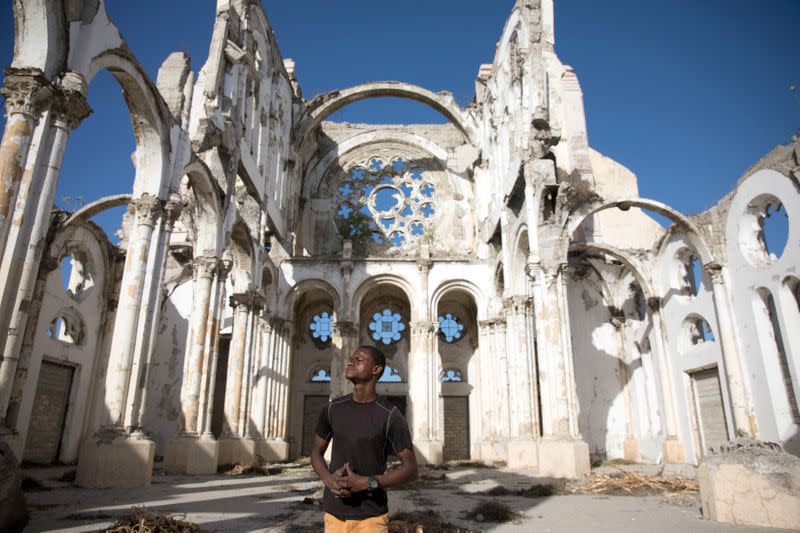 Paul Christandro posa para una foto dentro de la Catedral de Nuestra Señora de la Asunción, destruida por el terremoto de 2010, en Puerto Príncipe